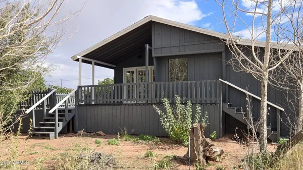 a view of a house with a wooden fence and trees