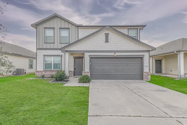 a front view of a house with a yard and garage