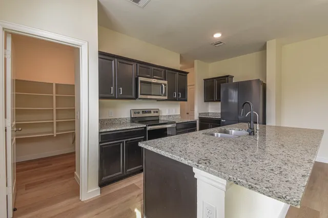 a kitchen with kitchen island a counter top space appliances and cabinets