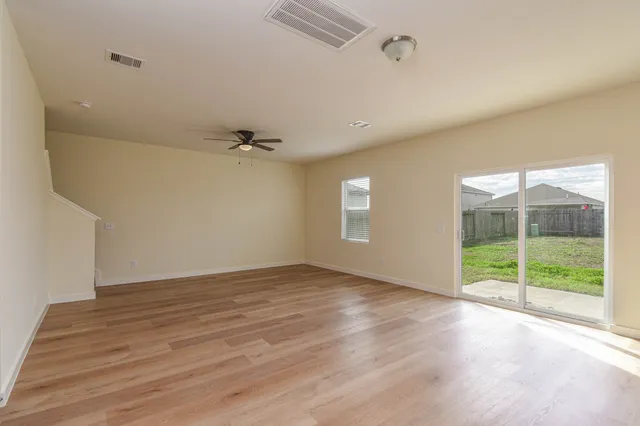 a view of an empty room with wooden floor