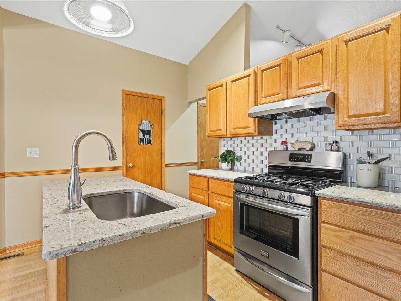 919 Gregory Way Winnebago, IL 61088 - Photo 12 of 47 a kitchen with a stove a sink and a microwave