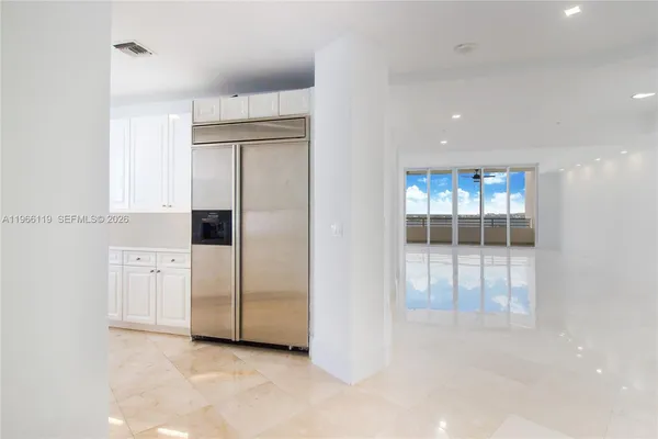 a kitchen with white cabinets and refrigerator