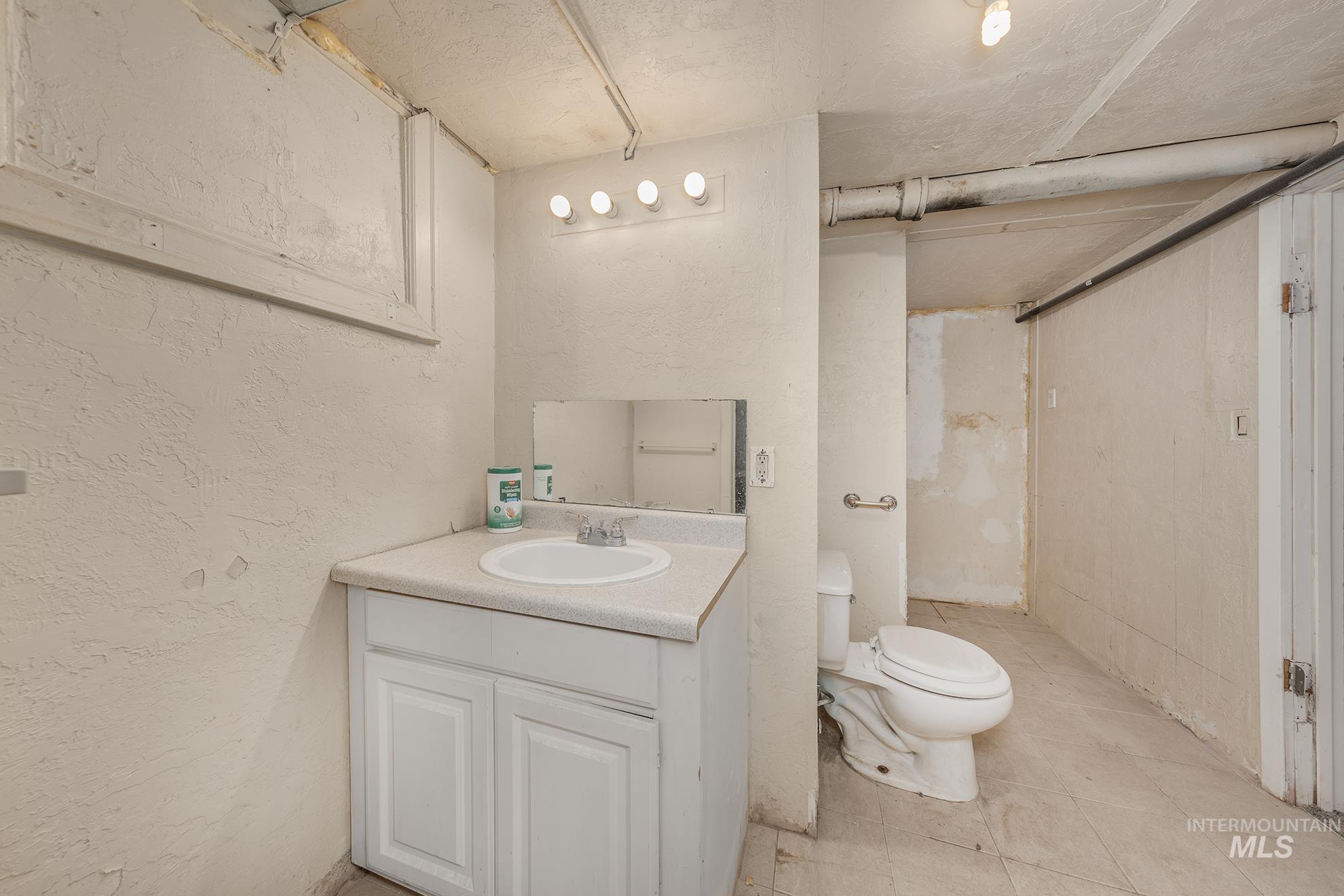 1602 2nd Avenue South Payette, ID 83661 - Photo 22 of 28 Full bathroom with a textured wall, vanity, light tile patterned floors, and a shower