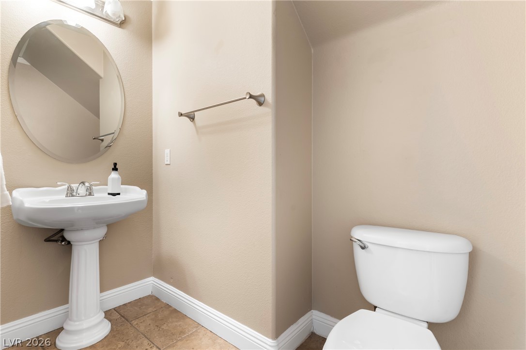 708 Vortex Avenue Henderson, NV 89002 - Photo 23 of 71 A well-maintained half-bath features a pedestal sink and tile flooring, providing comfort and style.