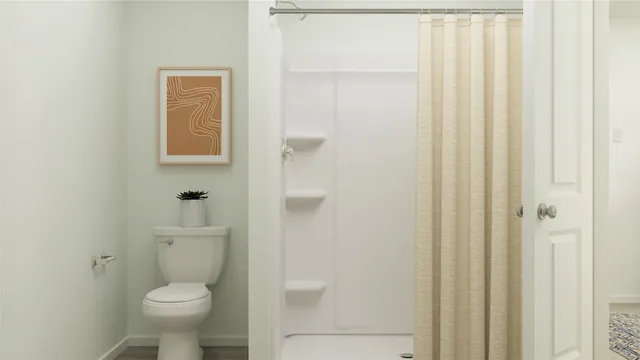 a bathroom with a toilet and a shower