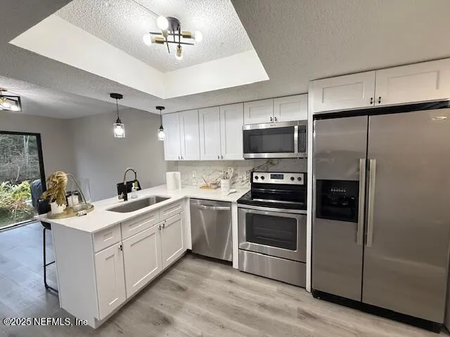 a kitchen with a sink stainless steel appliances and white cabinets