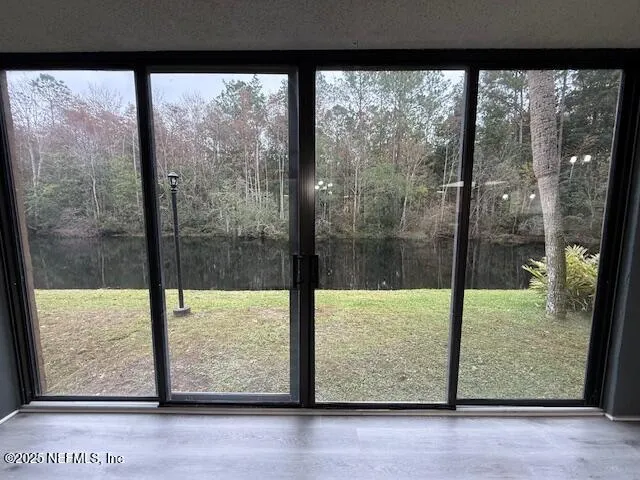 a view of a room with a large window and wooden floor