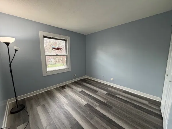 a view of water heater room with wooden floor