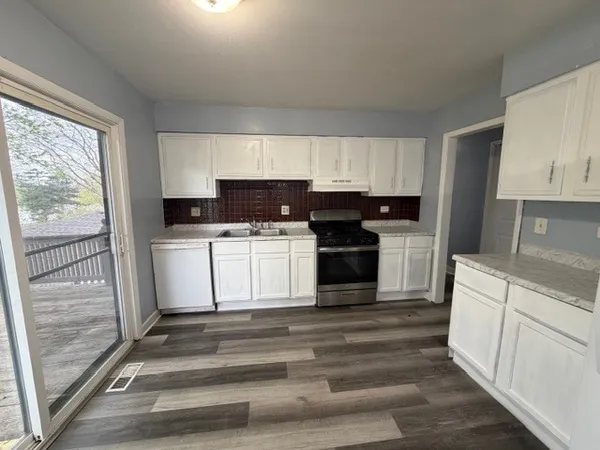 a kitchen with a refrigerator stove and white cabinets
