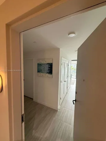 a view of a hallway with wooden floor and closet