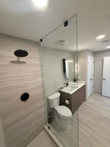 a bathroom with a toilet sink a mirror and shower