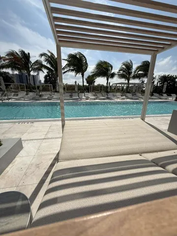 a large bed sitting in a bedroom and mirror