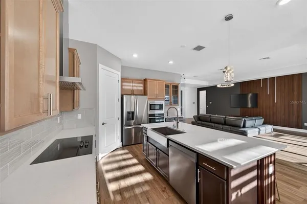 a kitchen with granite countertop a stove a sink a dining table and chairs