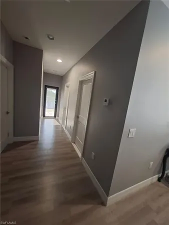 a view of a hallway with wooden floor and a living room