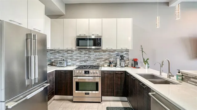 a kitchen with stainless steel appliances white cabinets and a stove top oven