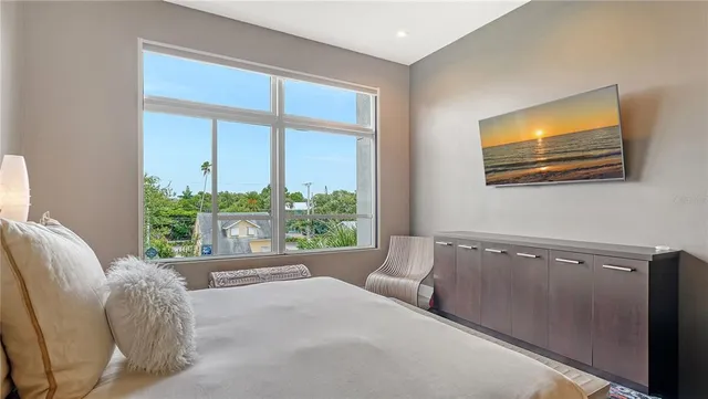 a large bed sitting in a bedroom and table chair