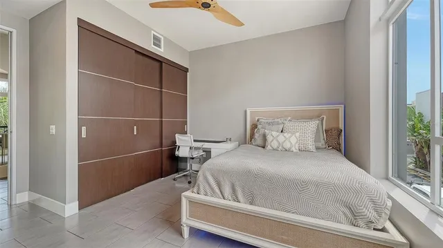 walk in closet with window and chandelier