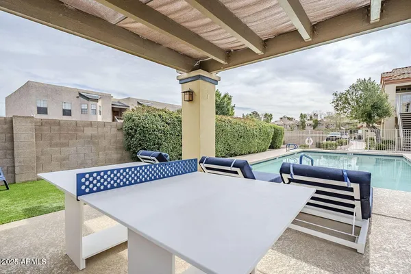 a view of a patio with a table chairs and a couple of flower plants