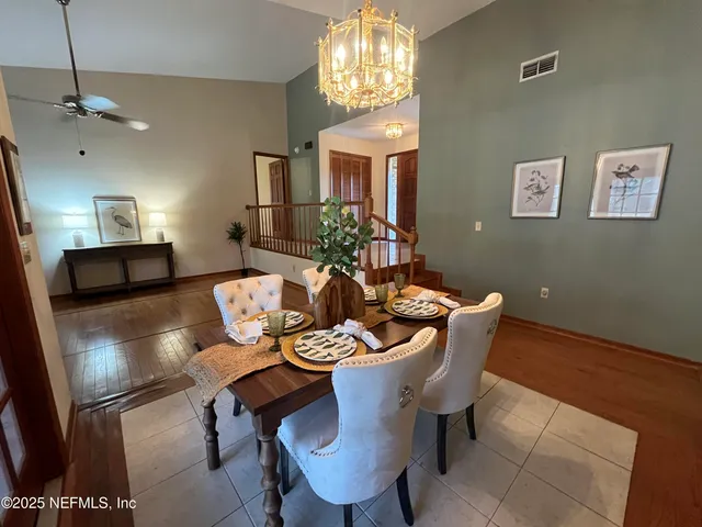 a living room with couches a dining table and kitchen view with wooden floor