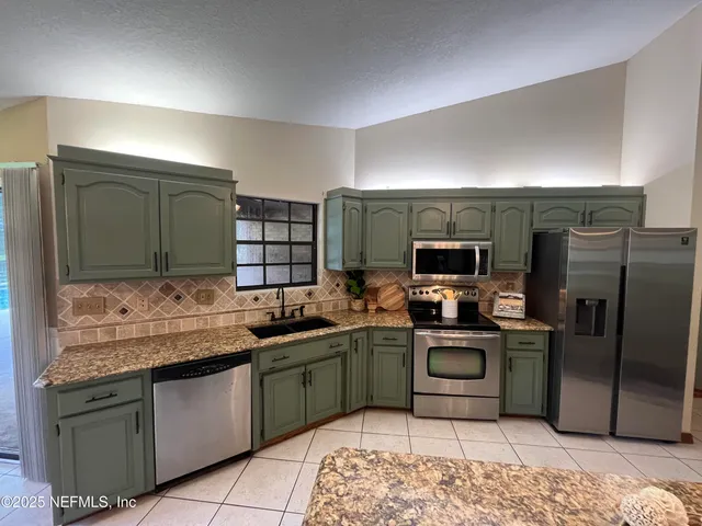 a bedroom with a bed a chandelier and window