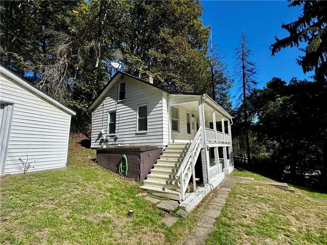 a view of a house with a yard balcony and wooden fence