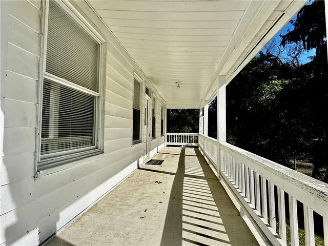 a view of balcony with wooden floor and potted plants