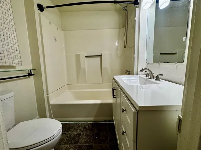 a bathroom with a sink a toilet a mirror and bathtub