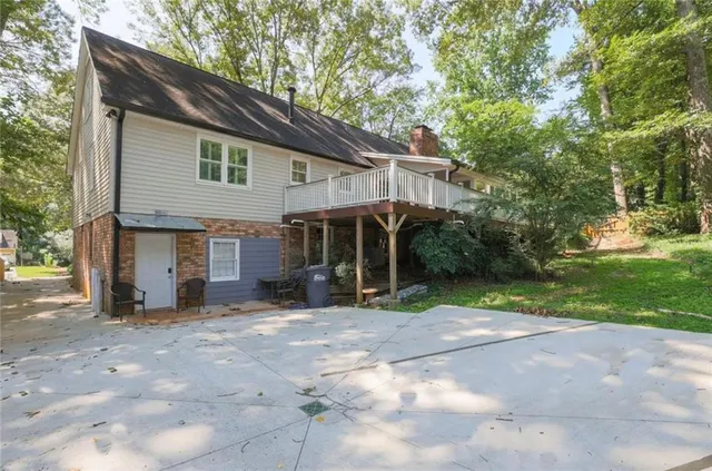 a view of a house with backyard and trees