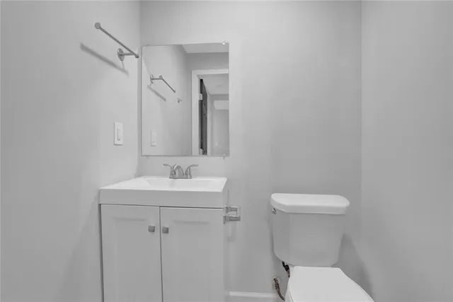 a bathroom with a toilet a sink and mirror
