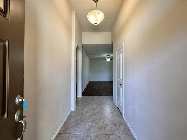 a view of a hallway with wooden floor and a cabinet