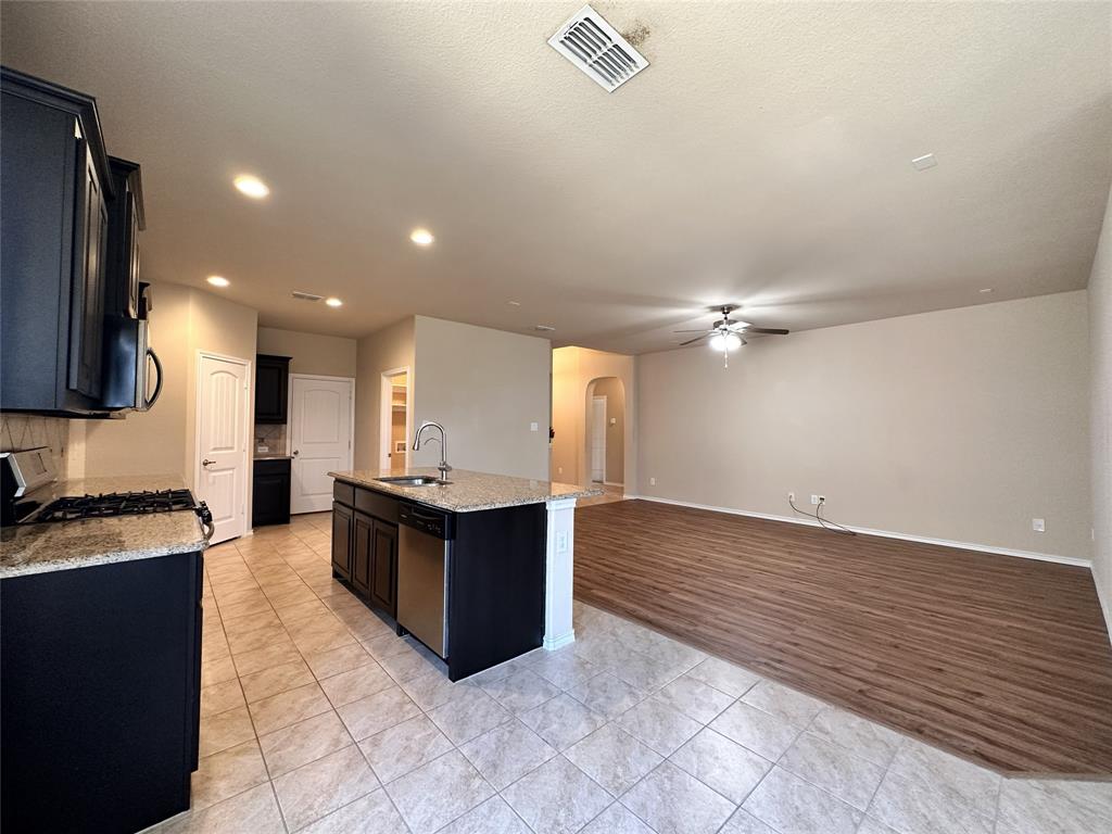 304 Cypress Crk Lane Denton, TX 76210 - Photo 5 of 24 a kitchen with granite countertop a stove and a sink