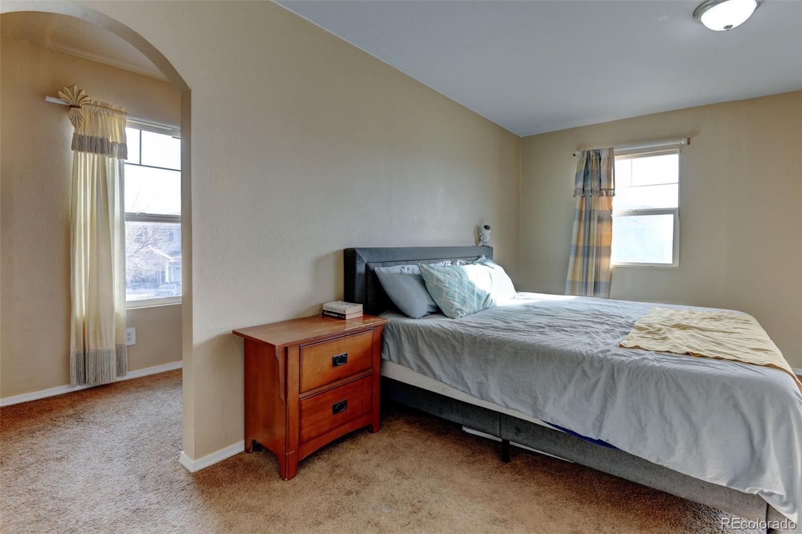 5555 Perth Court Denver, CO 80249 - Photo 18 of 31 a bed sitting in a bedroom next to a window