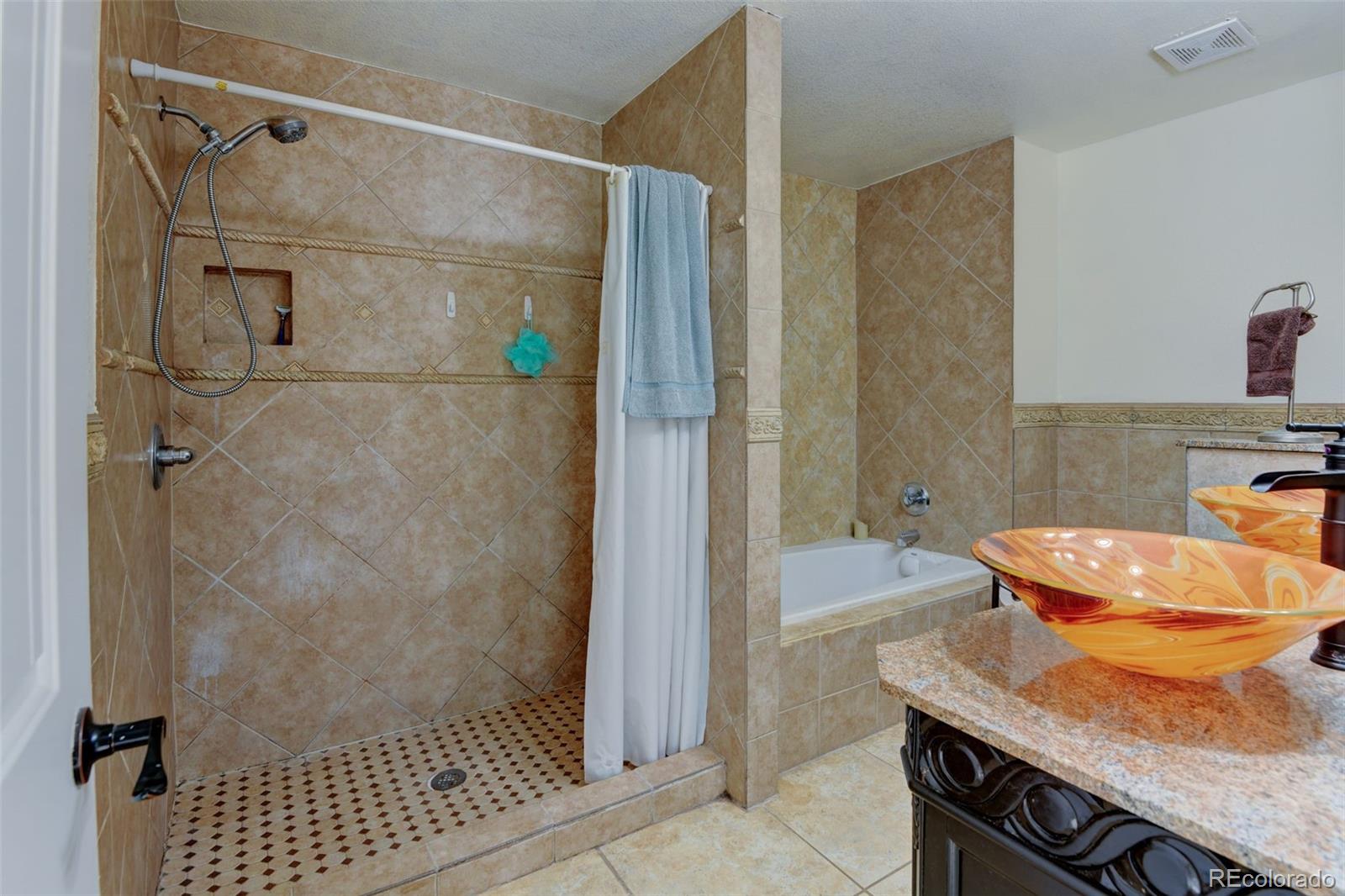 5555 Perth Court Denver, CO 80249 - Photo 20 of 31 a bathroom with a granite countertop bathtub shower sink and toilet