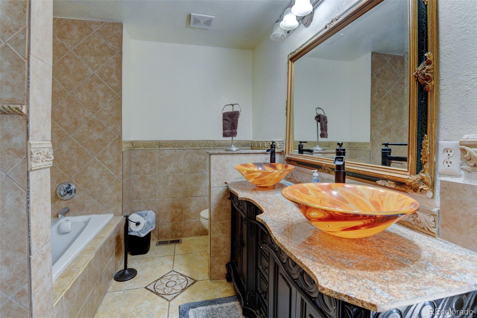 5555 Perth Court Denver, CO 80249 - Photo 21 of 31 a bathroom with a granite countertop sink and a mirror