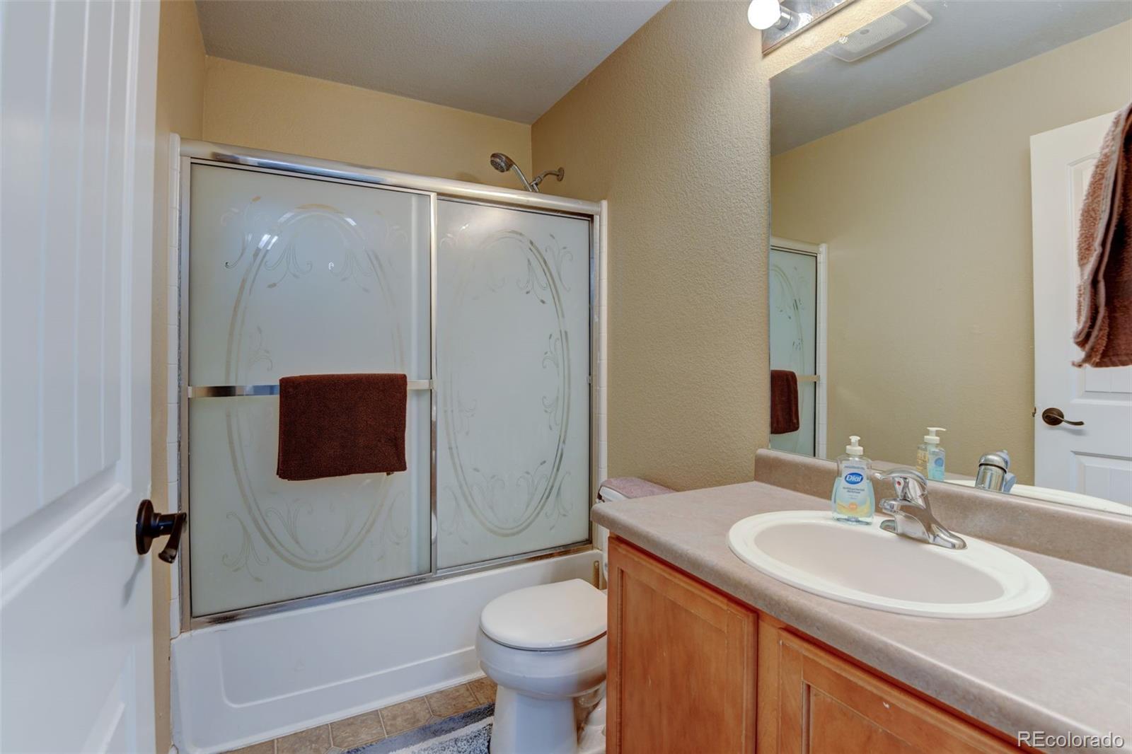5555 Perth Court Denver, CO 80249 - Photo 22 of 31 a bathroom with a sink toilet and shower