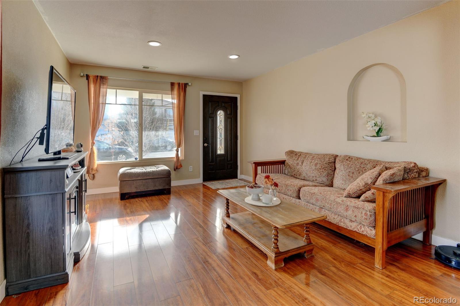 5555 Perth Court Denver, CO 80249 - Photo 4 of 31 a living room with furniture and a large window