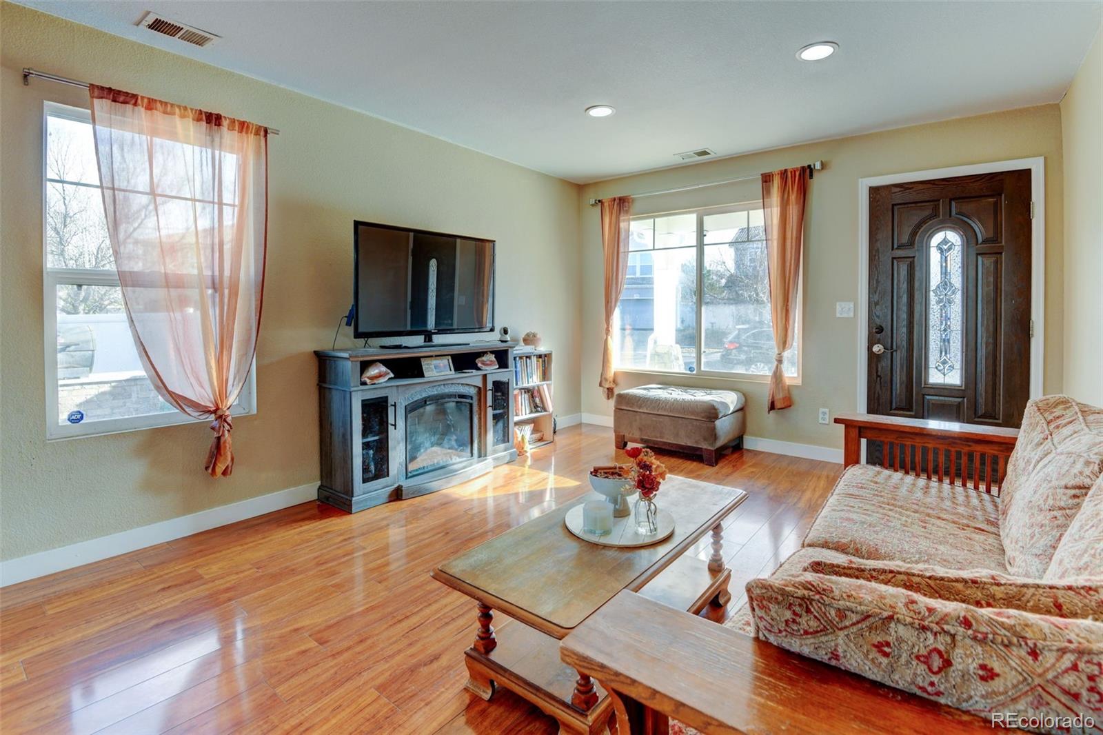 5555 Perth Court Denver, CO 80249 - Photo 7 of 31 a living room with furniture and a flat screen tv