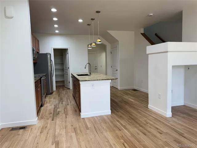 an open kitchen with a sink and refrigerator