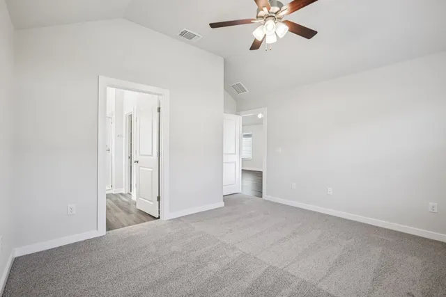 an empty room with a chandelier fan and closet area