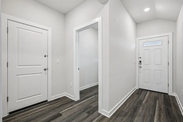 a view of a hallway with wooden floor