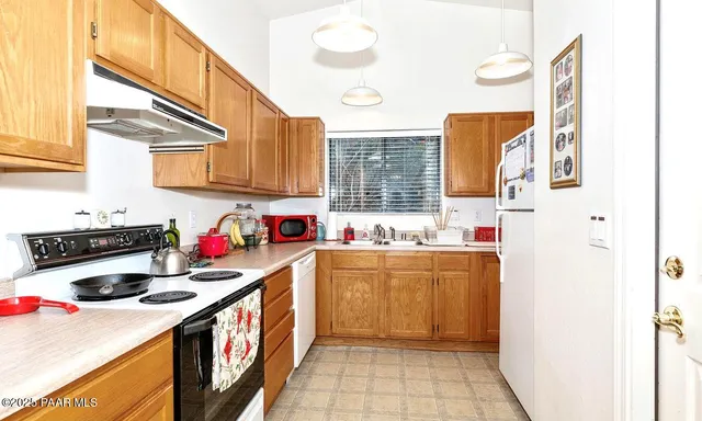 a kitchen with a sink a stove and cabinets