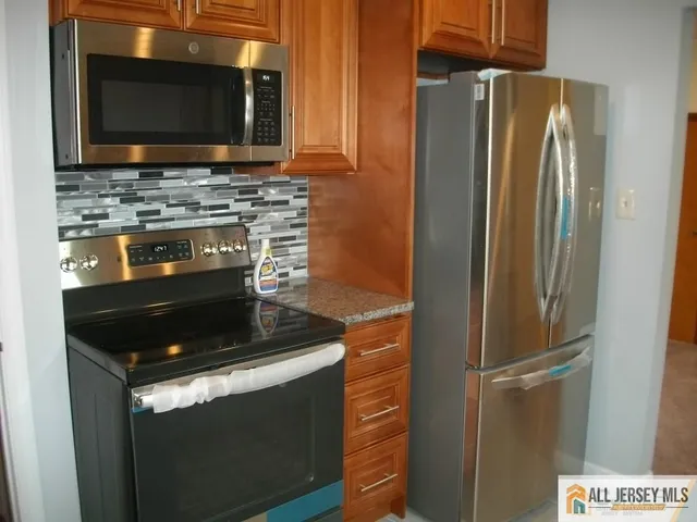 a kitchen with stainless steel appliances wooden cabinets and a stove