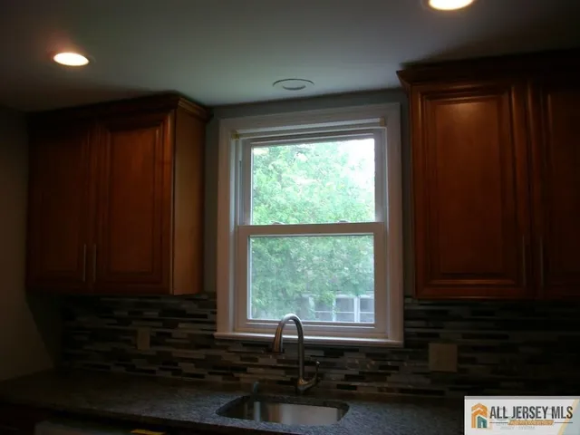 a view of a sink and wooden cabinets