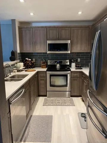 a kitchen with a sink stainless steel appliances and cabinets