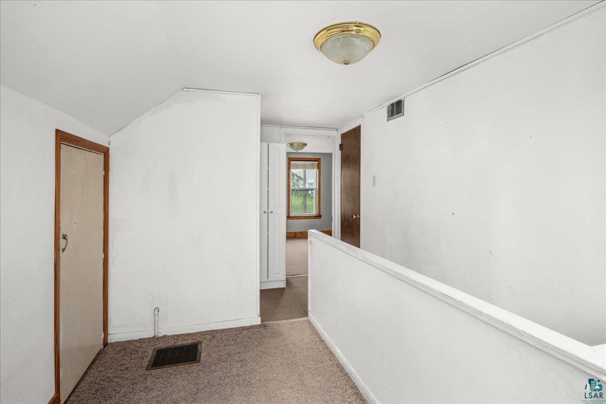 424 East Upham Road Duluth, MN 55811 - Photo 14 of 38 Carpeted flooring throughout a hallway with white walls and a white railing