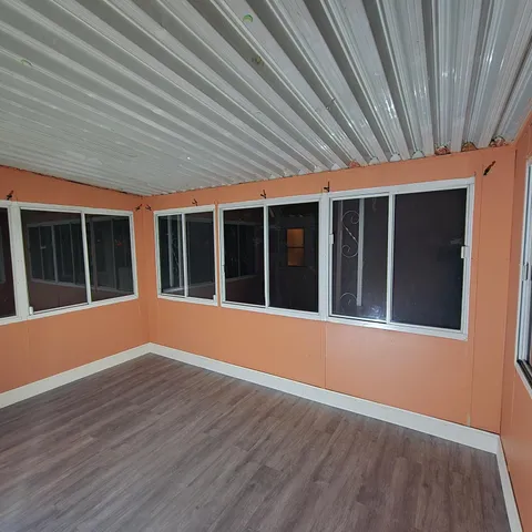 a view of a room that has wooden floor and a large window