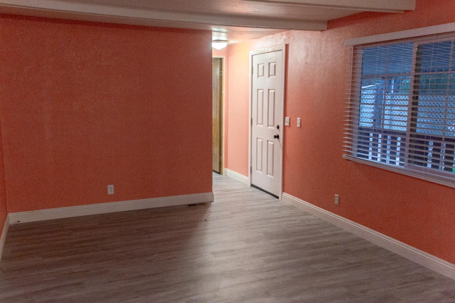 350 Pleasant Valley Road, Unit 8 Diamond Springs, CA 95619 - Photo 6 of 26 a view of an empty room with wooden floor and a window