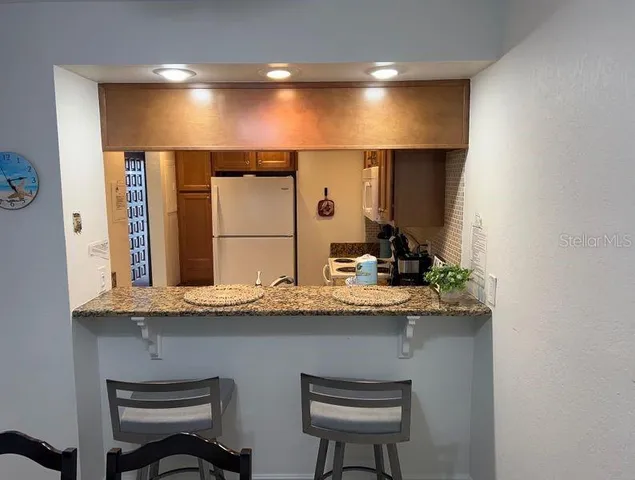 a bathroom with a granite countertop sink a toilet and a large mirror