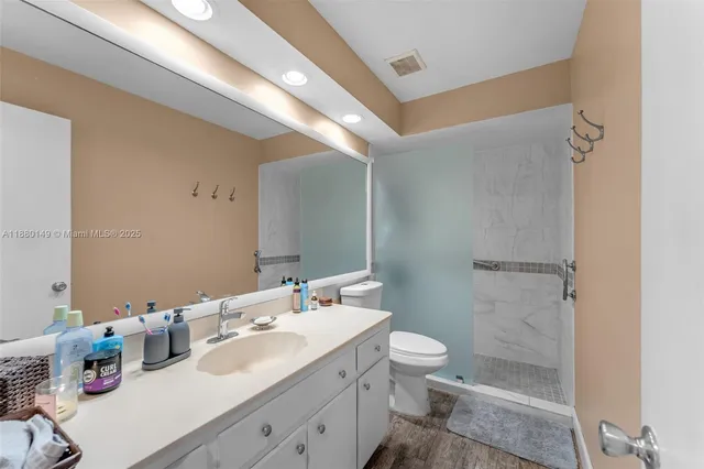a bathroom with a double vanity sink toilet and shower
