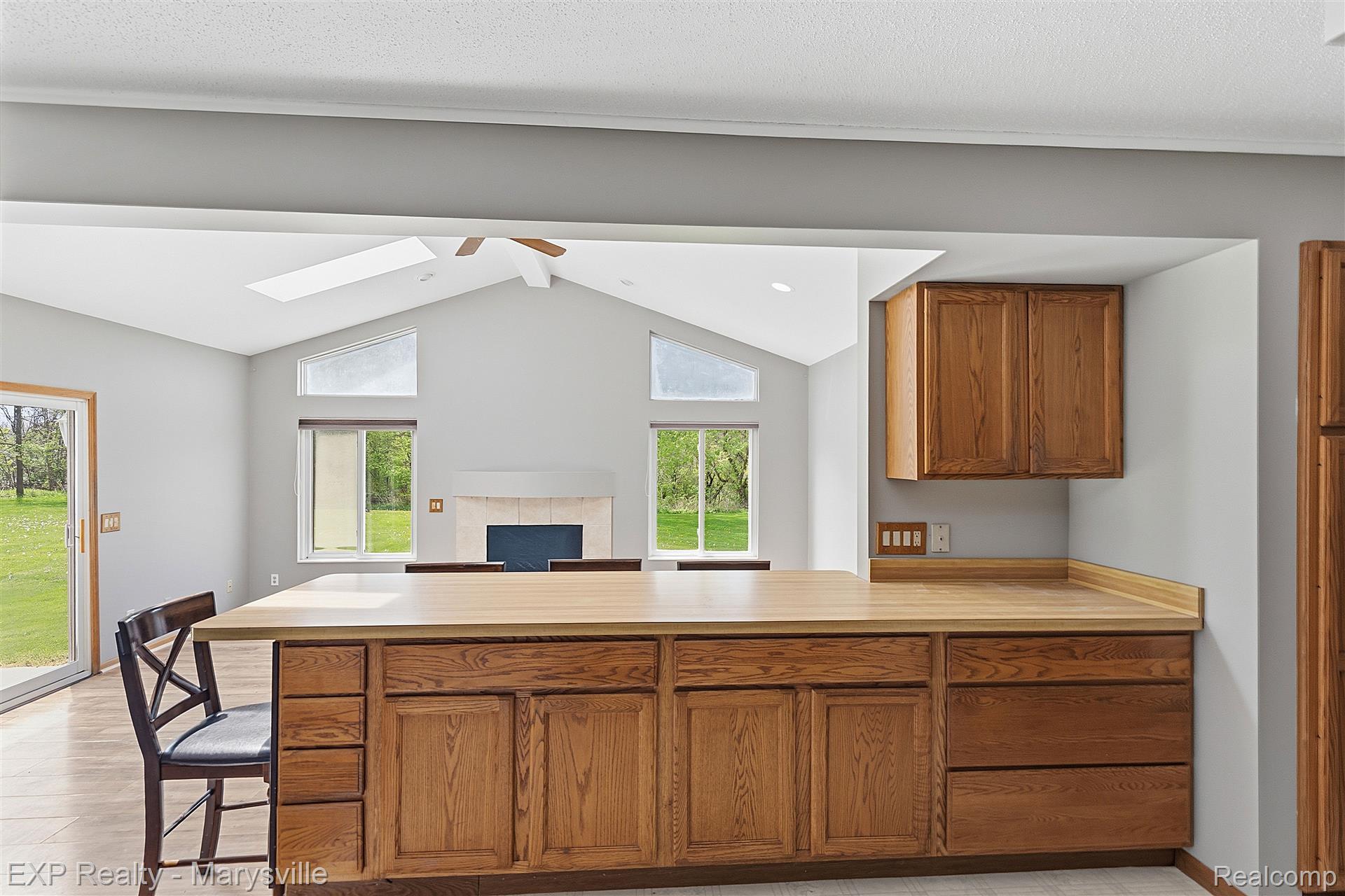 12265 Hough Road Memphis, MI 48041 - Photo 41 of 41 Kitchen with light countertops, a peninsula, a ceiling fan, wood finish cabinets, and open floor plan